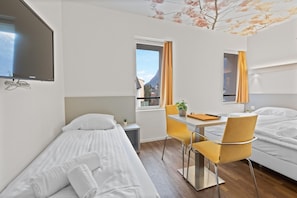 A hotel room with a bed, a desk, a chair, a TV, and a window with curtains. - Hôtel De La Poste Sierre (Sierre)