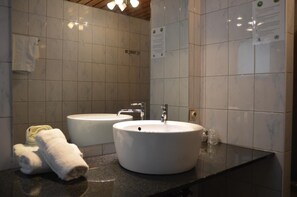 A bathroom with two sinks, a towel, and a mirror. - De Basiliek (Edegem)