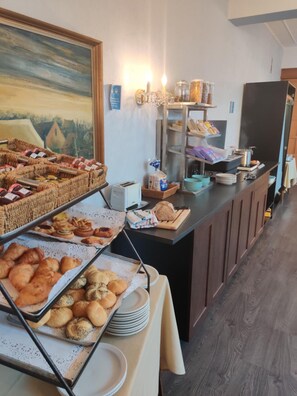 A buffet setup with various baked goods and beverages. - De Basiliek (Edegem)