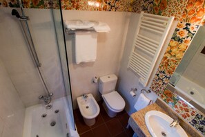 A bathroom with a shower, bidet, toilet, and sink. - Adeko Hotel (Barakaldo)