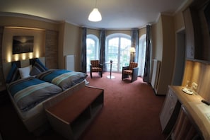 Una camera d'albergo con un letto, una scrivania, una sedia e vista sull'esterno.