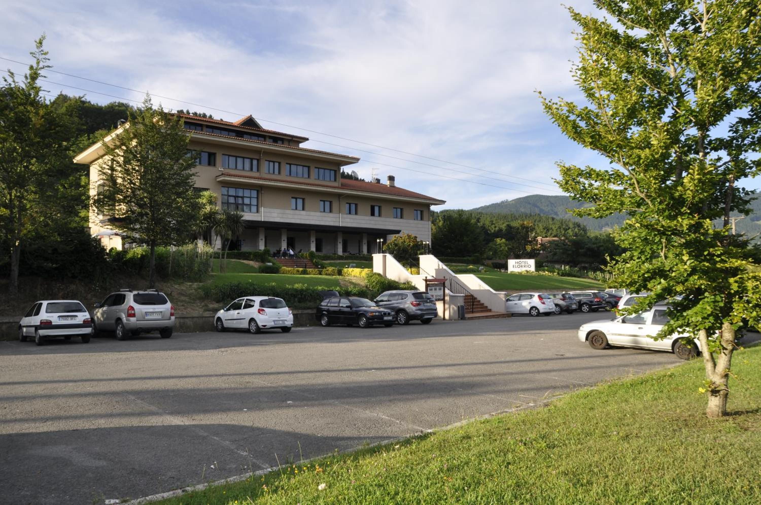 Un hôtel doté d’un parking et d’un bâtiment surmonté d’un toit rouge.