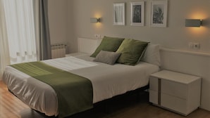 A neatly arranged bedroom with a bed, bedside tables, and wall-mounted lights. - Hotel Elorrio (Elorrio)