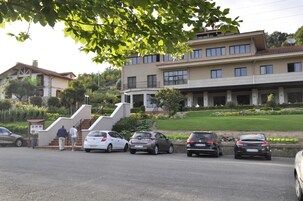 A multi-story building with a parking area in front.