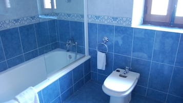 Un baño con bañera, inodoro y bidé.