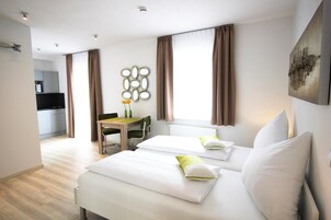 Una habitación de hotel con una cama, un escritorio y una silla.