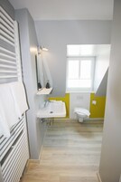 Baño con lavamanos blanco, inodoro y ventana.