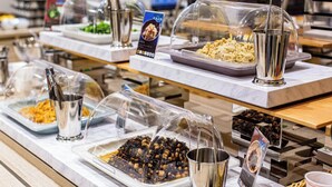 A buffet setup with various food items covered in clear plastic domes, including what appears to be nuts, seeds, and possibly some type of grain or cereal. - Kuretake Inn Premium Tajimi Ekimae (Tajimi)