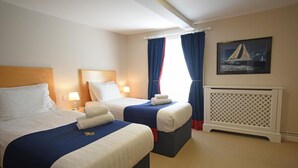 A hotel room with two beds, a radiator, and a painting on the wall. - Royal Southern Yacht Club (Southampton)