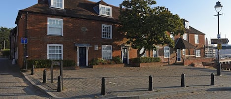 A traditional brick building with a central entrance, a clock, and a sign indicating a rope walk.