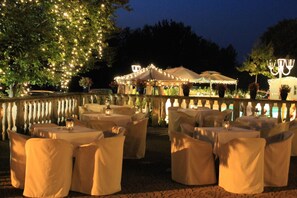 An outdoor dining area with tables and chairs, string lights, and umbrellas. - Villa Belvedere 1849 (Misano di Gera d'Adda)