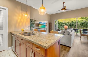Una cocina moderna con encimeras de granito, electrodomésticos de acero inoxidable y una isla grande.