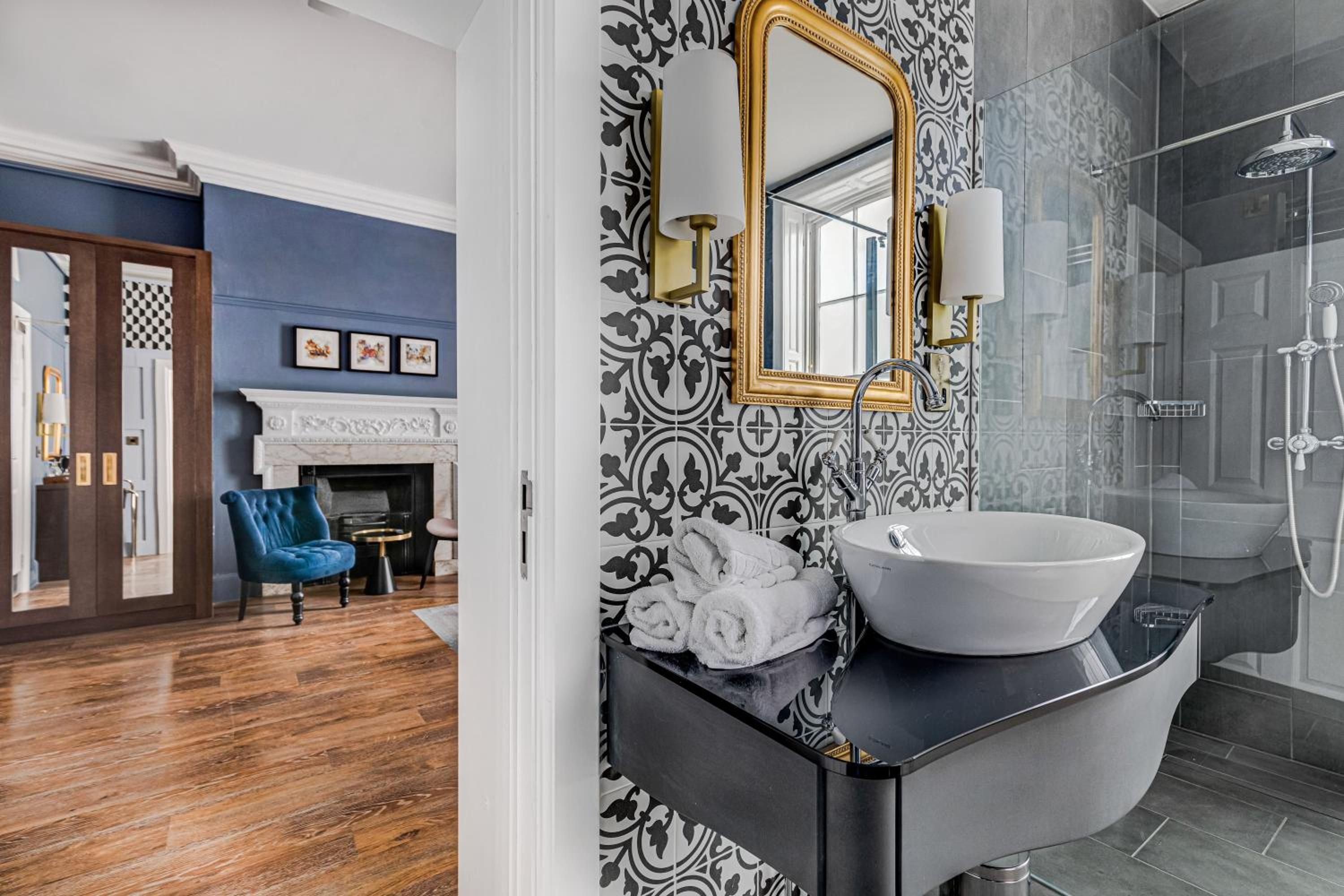 A bathroom with a black vanity, a white sink, and a shower with a glass enclosure.