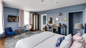 Een hotelkamer met een bed, een bureau, een stoel, een kaptafel en een televisie.