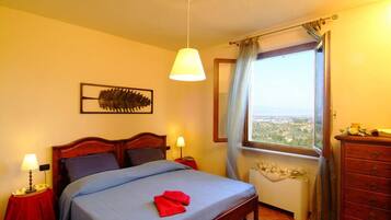 Un dormitorio con una cama, lámparas de noche, una ventana con vistas y un aparador de madera.