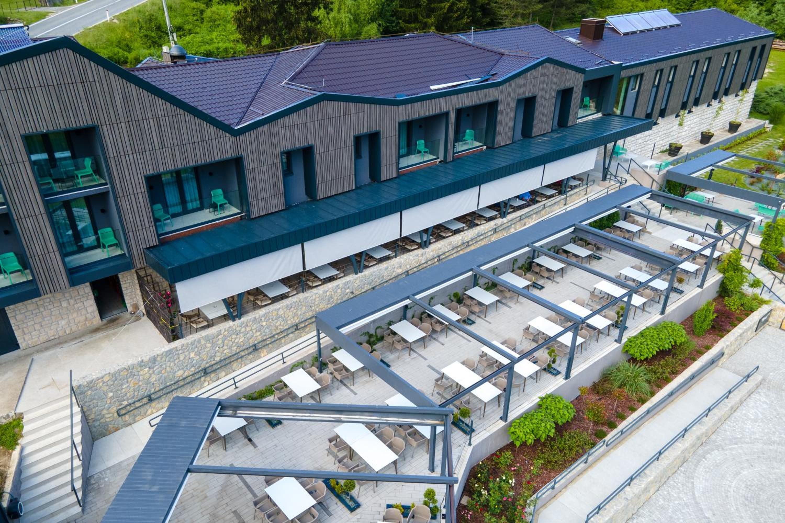 Ein modernes Gebäude mit flachem Dach, mehreren Balkonen und Außenbereich-Sitzgelegenheiten.