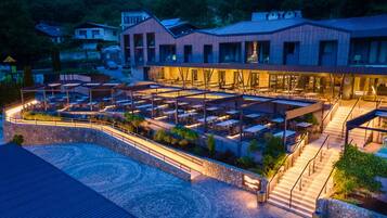 A hotel with a pool area, outdoor seating, and a stone pathway.
