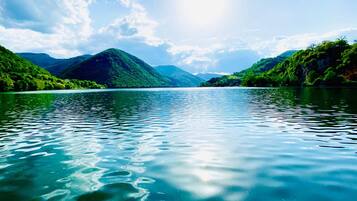 A calm lake surrounded by lush green hills.