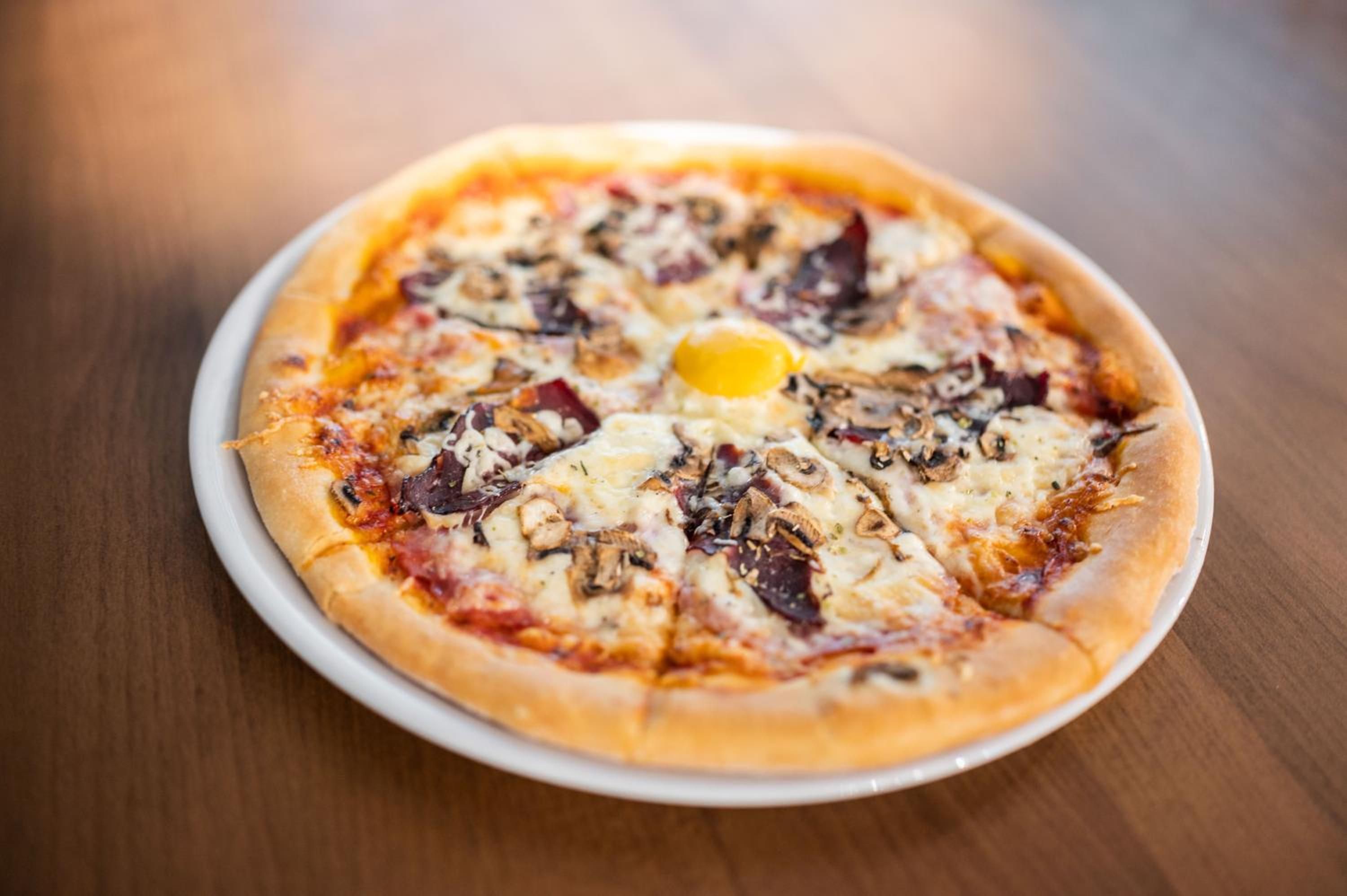 A pizza with various toppings on a white plate.