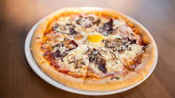 A pizza with various toppings on a white plate.