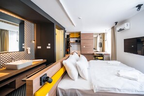 A hotel room with a bed, a bedside table, a mirror, a sink, and a wardrobe. - Hotel Plivsko Jezero (Jajce)