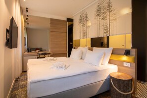 A hotel room with a bed, bedside table, and a mirror.