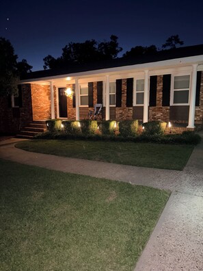A house with a brick facade, a covered porch, and a well-maintained lawn. - Welcome to Woosah. King size bed with a pool. (Augusta)