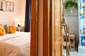 Une chambre à coucher avec un lit, une table de chevet, une lampe et une fenêtre avec des rideaux.