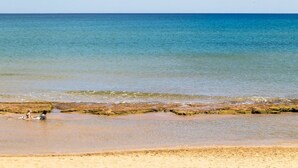 Uma praia com águas cristalinas e uma faixa de areia.