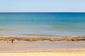 Ein Strand mit klarem Wasser und sandigem Ufer.