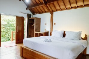 A bedroom with a wooden bed, a wardrobe, and a view of greenery outside. - Nea Cottage Lombok (Tetebatu)
