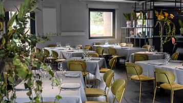 Un restaurant doté de nombreuses tables et chaises, chacune étant mise avec des assiettes, des couverts et des verres.