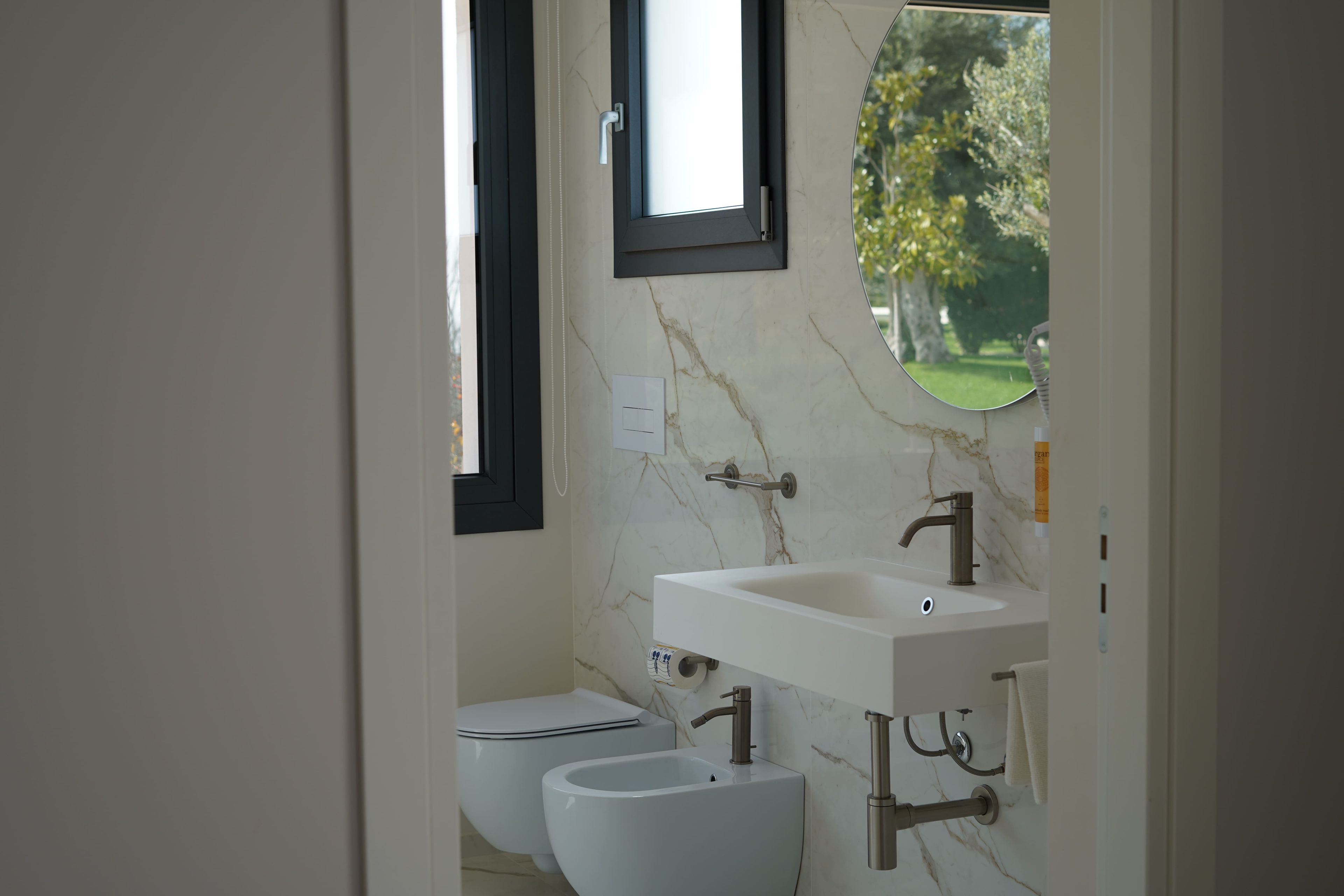 A bathroom with a white sink, a mirror, and a toilet.