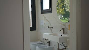 A bathroom with a white sink, a mirror, and a toilet.