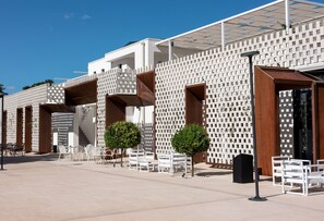 Un edificio moderno con fachada blanca, varios balcones y zonas de estar al aire libre.