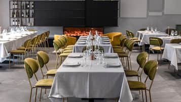 Ein Restaurant mit gedeckten Tischen, Stühlen und einem Kamin im Hintergrund.