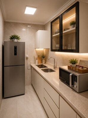 Una cocina moderna con refrigerador incorporado, microondas y lavaplatos.