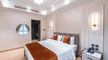 Quarto de hotel moderno com uma cama grande, mesas de cabeceira, um espelho e um telefone na mesinha de noite.