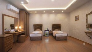 A hotel room with two beds, a vanity with a mirror, a dresser, and a ceiling with recessed lighting. - Al-manar Hotel (Giza)