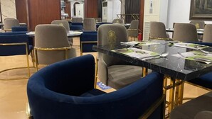 A hotel dining area with round tables, cushioned chairs, and a modern interior design. - Al-manar Hotel (Giza)