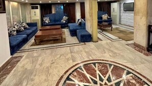 A spacious living area with a curved ceiling, a central coffee table, and blue sofas. - Al-manar Hotel (Giza)