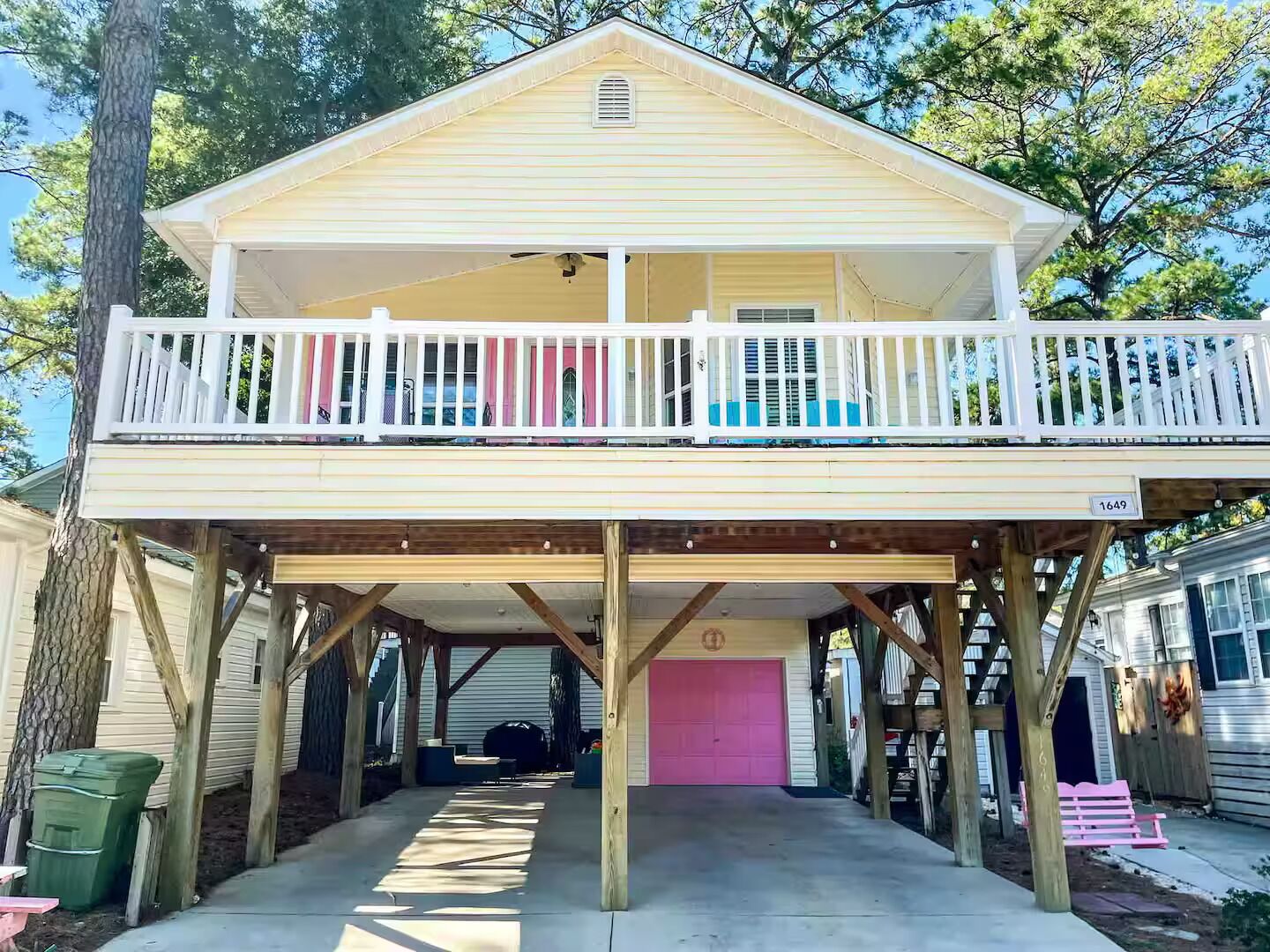 Ein zweistöckiges Haus mit Balkon, Garage und überdachter Veranda.