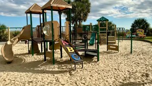 A sandy playground with climbing structures and slides. - Emmas Beach Hut 2 KING BEDS 3 min to beach (Myrtle Beach)