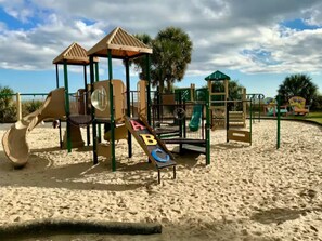Ein Sandspielplatz mit Klettergerüsten und Rutschen.