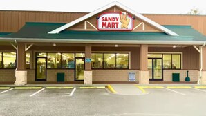 A Sandy Mart store with a green roof, large windows, and a parking lot in front. - Emmas Beach Hut 2 KING BEDS 3 min to beach (Myrtle Beach)