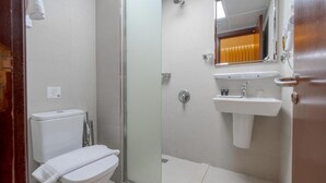 A bathroom with a toilet, a glass-enclosed shower, and a sink with a mirror above it. - Maysan Rotana El Mysk Fully Renovated (Madinah)