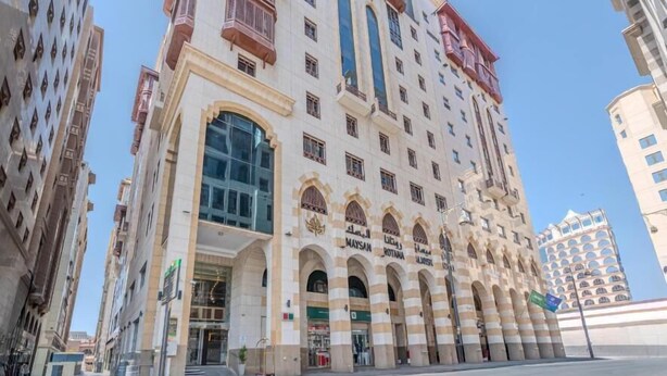 A multi-story hotel with a prominent entrance, large windows, and a series of balconies. - Maysan Rotana El Mysk Fully Renovated (Madinah)