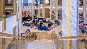 A spacious lobby with a marble floor, multiple seating areas, and a staircase with a glass railing. - Glee Nairobi Hotel (Nairobi)