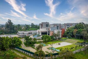 A modern building complex with multiple structures, a central courtyard with a pool, and surrounding greenery. - Glee Nairobi Hotel (Nairobi)