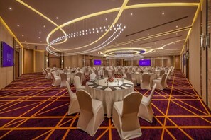 A banquet hall with round tables, white chairs, and a patterned carpet. - Glee Nairobi Hotel (Nairobi)